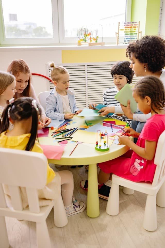 Educator helping children paint with watercolours