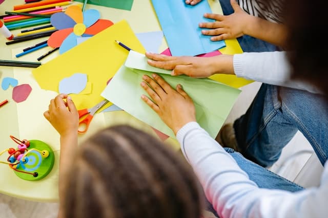 Children and educators making paper crafts